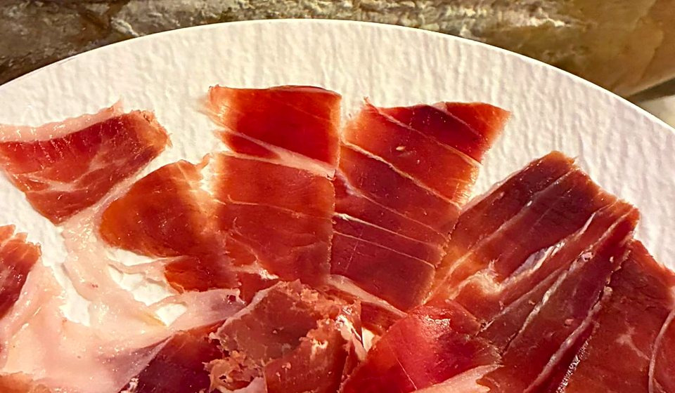 The owner's phone photo of hand-cut jamón ibérico fanned on a white plate